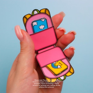 May include: A pink papercraft phone with a yellow and blue design. The phone is open, revealing a blue screen with white clouds and a yellow screen with a rainbow and the text "Lunch & You".