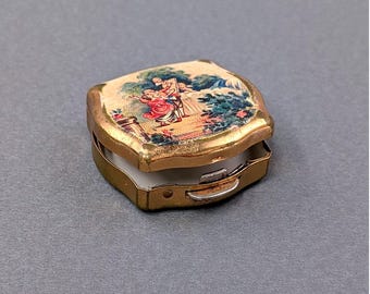 Pastillero antiguo Stratton England Fragonard con escena pastoral y parte trasera en tono dorado con estrella.