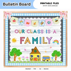Op de afbeelding: Een prikbord met de tekst "OUR CLASS IS A FAMILY" in kleurrijke letters. Het ontwerp bevat een witte achtergrond met houtnerf, een blauwe ruitjesrand met roze strikken, een vlaggetjesslinger en kleurpotloodtekeningen van een huis, bomen, een bus en een zon.