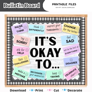 May include: A bulletin board display featuring a white wood-grain background with a black and white buffalo check border. The text IT'S OKAY TO... is centered in large black letters, surrounded by colorful rectangular cards with positive phrases.