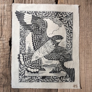 May include: Black and white print of a Common Nighthawk in flight, framed by a decorative border of leaves and insects. The artwork depicts a detailed landscape with trees and a lake. The print is numbered 39/40.