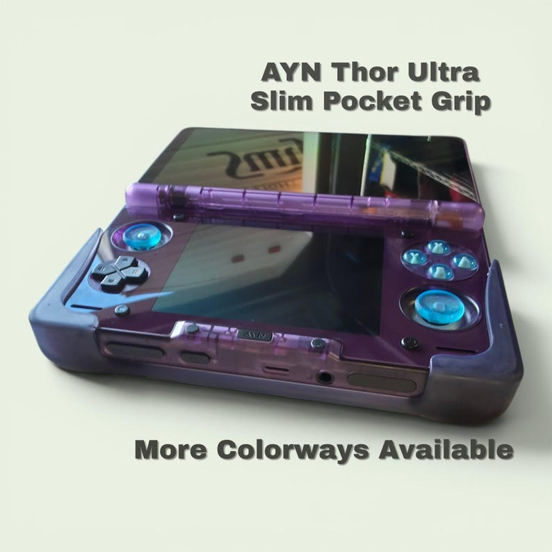 Puede incluir: Una funda de consola de juegos port&aacute;til de color morado transl&uacute;cido etiquetada como AYN Thor Ultra Slim Pocket Grip. El dispositivo cuenta con una carcasa morada oscura, joysticks azul brillante y una cruceta. El texto AYN Thor Ultra Slim Pocket Grip y More Colorways Available es visible.