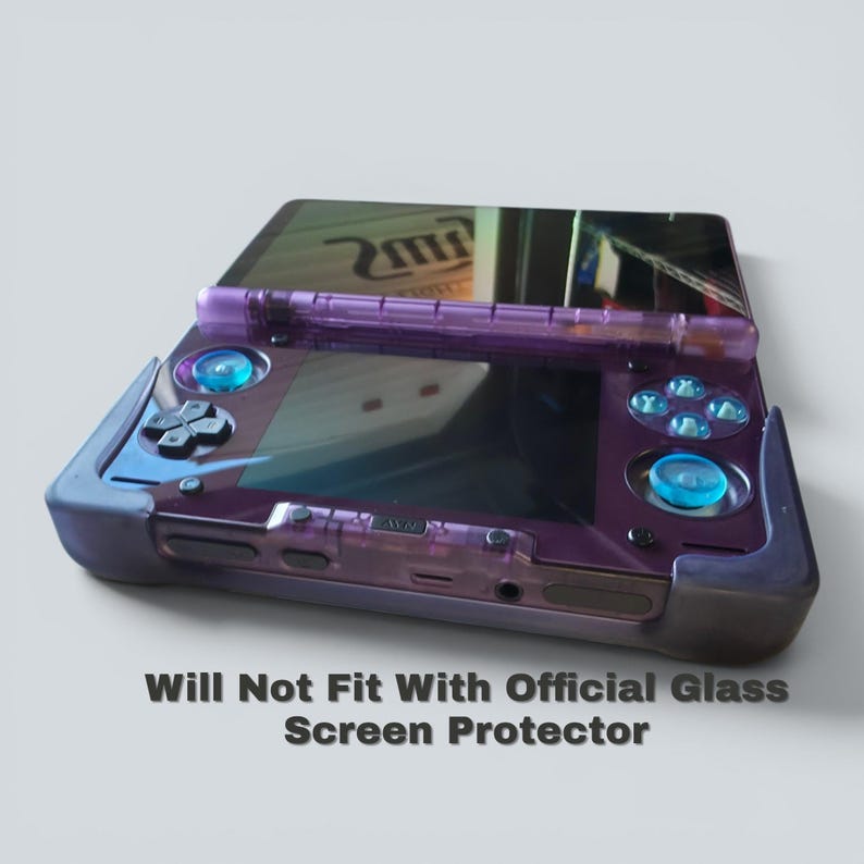 Puede incluir: Una consola de juegos port&aacute;til transl&uacute;cida de color p&uacute;rpura con una funda protectora oscura, joysticks azules y un pad direccional. La pantalla refleja la luz y el texto "Will Not Fit With Official Glass Screen Protector" aparece impreso debajo.
