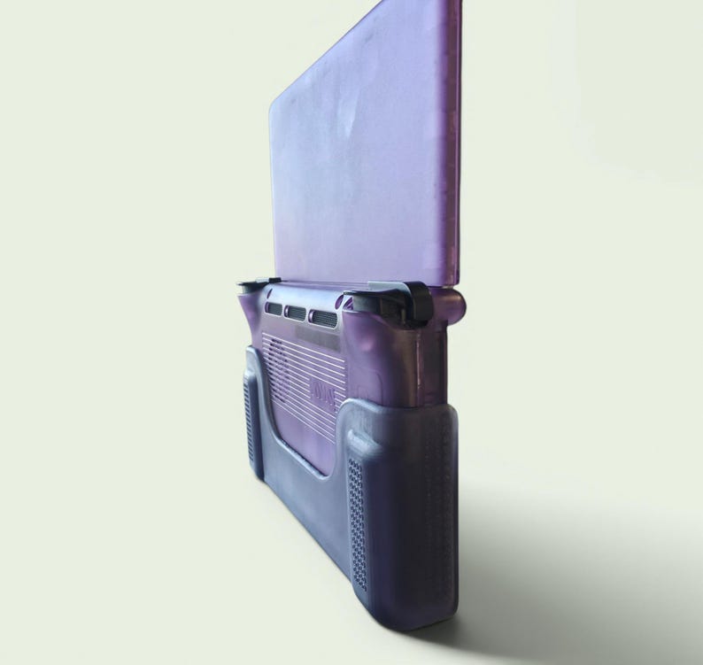 Puede incluir: Una consola de juegos port&aacute;til con una carcasa de pl&aacute;stico p&uacute;rpura transl&uacute;cido. El dispositivo tiene una orientaci&oacute;n vertical con una pantalla en la mitad superior y una secci&oacute;n de agarre en la mitad inferior, incluyendo rejillas de ventilaci&oacute;n.