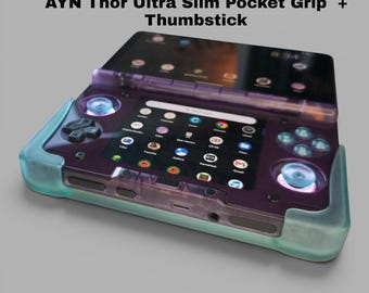 May include: A purple translucent handheld gaming console with a light blue grip and thumbsticks. The screen displays an app grid. Text above reads: AYN Thor Ultra Slim Pocket Grip + Thumbstick. The device features a D-pad, buttons, and ports.