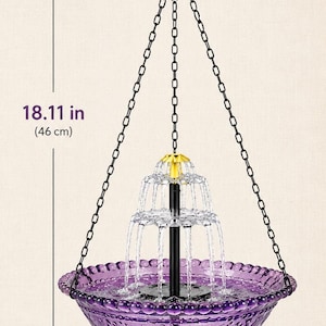 May include: A purple glass hanging bird bath fountain with a black central pillar and a yellow top nozzle. It features a black chain for suspension. The total height is 18.11 inches and the diameter of the bowl is 9.25 inches, as indicated.