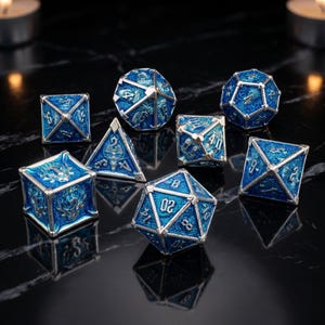 May include: A set of eight blue and silver metal dice in various geometric shapes. Each die features intricate dragon-themed detailing and white numbering. The dice are arranged on a dark, reflective surface.