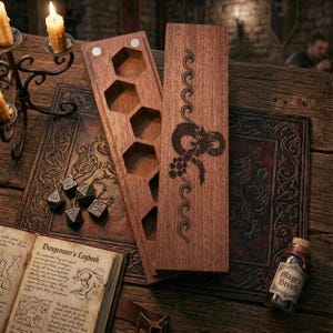 Puede incluir: Una caja de dados de madera con un diseño de dragón, abierta para revelar compartimentos hexagonales. Junto a ella hay dados de metal, un libro abierto titulado "Dungeoneer's Logbook" y una pequeña botella etiquetada como "Mage's Breath". La escena está ambientada en una mesa de madera con velas encendidas.