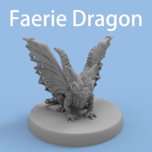 Puede incluir: Una figura miniatura gris sin pintar de un Faerie Dragon con alas grandes y detalladas, cuernos y escamas texturizadas, sobre una base circular. El texto Faerie Dragon aparece en blanco sobre la criatura con un fondo azul claro.