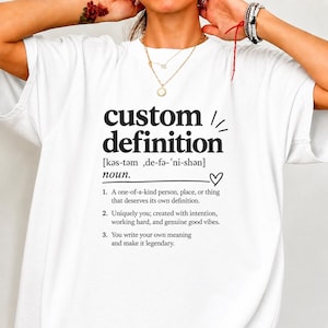 May include: A white t-shirt featuring black text that reads custom definition, followed by a phonetic pronunciation, the noun label, a heart symbol, and three numbered points describing the concept of a one-of-a-kind person, place, or thing.
