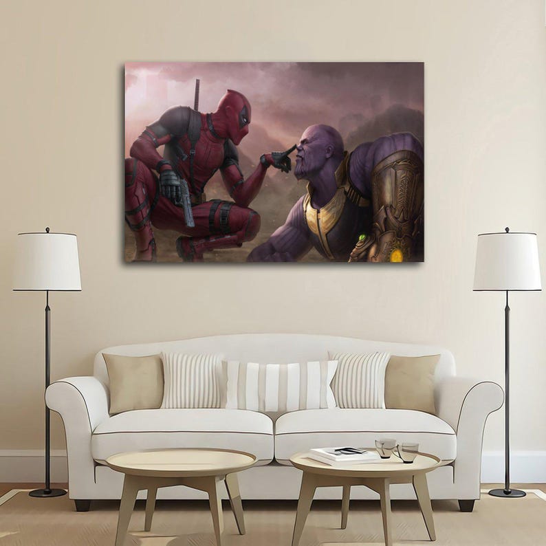 May include: A canvas print featuring Deadpool and Thanos in a dramatic pose. Deadpool, in his red and black suit, points a finger at Thanos, who is purple and wearing the Infinity Gauntlet. The background is a hazy, muted landscape.