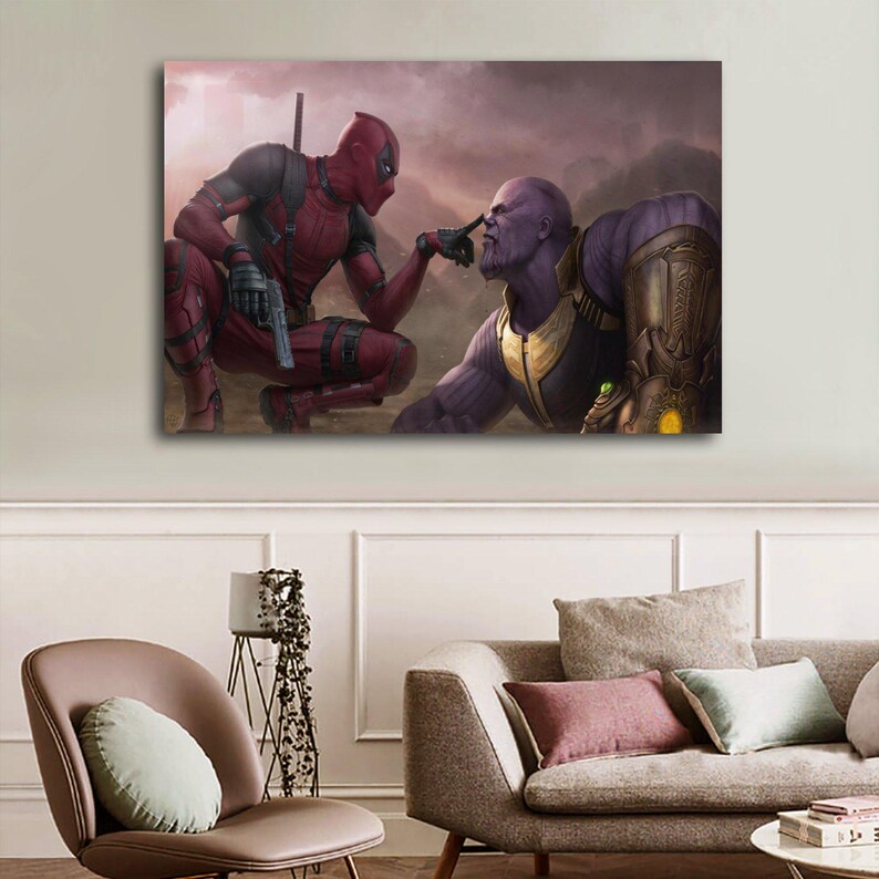 May include: A canvas print featuring Deadpool and Thanos in a dramatic pose. Deadpool, in a red and black suit, points at Thanos, who is in a gold and purple armored suit. The background is a hazy, mountainous landscape.