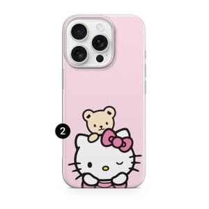 Puede incluir: Funda de tel&eacute;fono rosa con un dise&ntilde;o de Hello Kitty y un oso de peluche. La funda tiene un borde transparente y un fondo rosa. Hello Kitty es blanca con un lazo rosa y gui&ntilde;a un ojo.