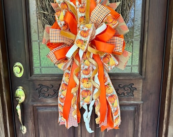 Lazo otoñal con cintas de calabaza y detalles naranjas, decoración otoñal para el hogar.