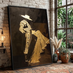 Könnte beinhalten: Ein gerahmtes Kunstwerk mit einer goldfarbenen Matadorfigur auf schwarzem Hintergrund. Der Matador ist in einem traditionellen Anzug mit Hut und Umhang dargestellt. Das Kunstwerk wird in einem Raum mit einer Backsteinmauer und einem Fenster ausgestellt.