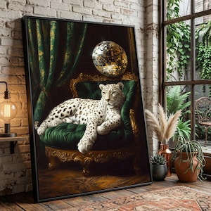 May include: A framed print shows a snow leopard lounging on a green velvet chair. A disco ball hangs above the leopard. The background includes green curtains and a gold-trimmed chair. The artwork is displayed in a room with a brick wall and a window.