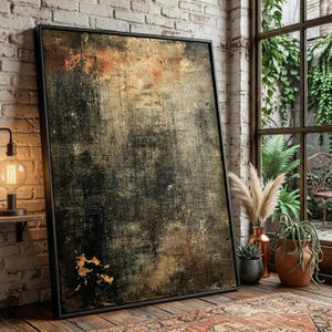 Könnte beinhalten: Großer gerahmter Kunstdruck mit einem strukturierten, verwitterten Aussehen. Das Kunstwerk zeigt eine Mischung aus Dunkelgrau, Braun und Goldtönen, die eine Vintage- oder Industrieästhetik erzeugt. Der schwarze Rahmen verleiht dem Stück eine moderne Note.