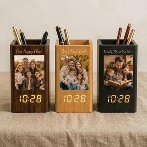May include: Three rectangular wooden pen holders with digital clocks displaying 10:28. Each holder features a custom photo print and engraved text: Our Happy Place, Best Dad Ever, and Daddy, You're Our Hero. Pens are stored in the top compartments.