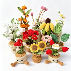 Puede incluir: Una colección de flores de ganchillo hechas a mano en varios colores y estilos, incluyendo girasoles, margaritas y rosas rojas. Cada flor está plantada en una maceta pequeña y sonriente con patas, creando una exhibición caprichosa y encantadora. Las flores están dispuestas sobre un fondo blanco.