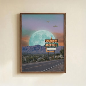 Op de afbeelding: Ingelijste kunstdruk met een retro motelbord "Starlight Motel", een woestijnlandschap, een grote maan en twee UFO's in de lucht. Het kunstwerk heeft een vintage, buitenaardse uitstraling.