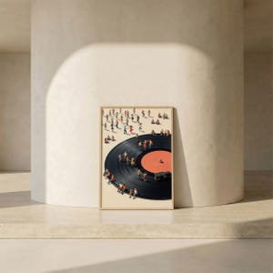 Puede incluir: Impresi&oacute;n art&iacute;stica enmarcada que presenta un disco de vinilo negro con un centro rojo. Peque&ntilde;as figuras de personas bailan y est&aacute;n sentadas en el disco. La obra de arte tiene un fondo beige y un marco marr&oacute;n claro, creando una escena caprichosa y art&iacute;stica.