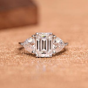 Elegante anillo de compromiso de tres piedras con corte esmeralda, piedras laterales de un trillón, anillo de bodas de moissanita, anillo de propuesta, regalo de aniversario o cumpleaños.