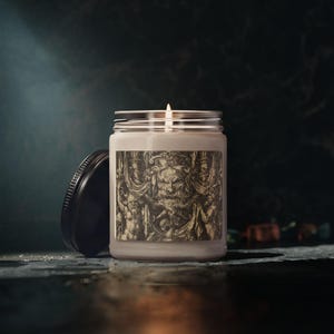 May include: A white ceramic mug with a black handle and the text "But First, Coffee" in a bold, black font. The mug is set against a blurred background, suggesting a cozy setting.