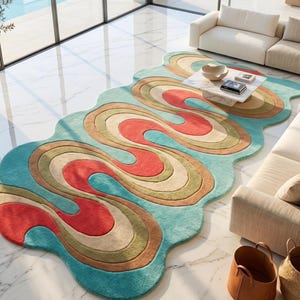 May include: A colorful, wavy area rug with a light blue background and a pattern of red, tan, green, and cream-colored swirls. The rug is placed on a marble floor in a modern living room setting.