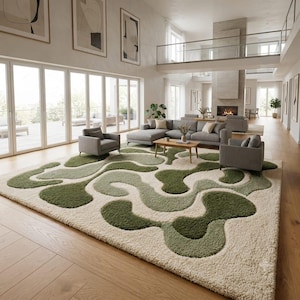 May include: A large rectangular area rug featuring a high-pile texture with an abstract pattern of flowing, organic shapes in varying shades of sage green, olive green, and cream. The rug covers a significant portion of the light wood floor.