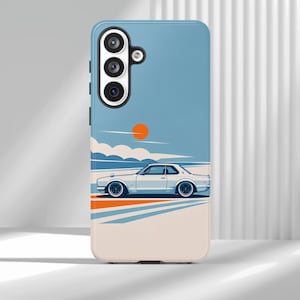 Puede incluir: Una funda de smartphone azul claro con una ilustración gráfica de un coche coupé vintage blanco conduciendo por una carretera. El diseño incluye un sol naranja brillante en un cielo azul, nubes blancas y rayas geométricas naranjas y azules.