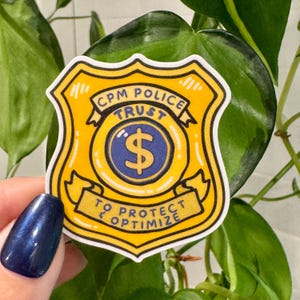 May include: A yellow and black sticker in the shape of a police badge. The sticker has the words "CPM POLICE TRUST" and "TO PROTECT & OPTIMIZE". A blue dollar sign is in the center of the badge.