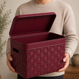 May include: A rectangular storage bin in a deep burgundy color featuring a woven exterior pattern and a matching lid. The bin has integrated side handles and a smooth, solid-colored rim along the top edge, providing a structured container design.