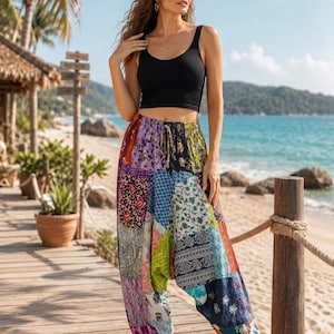 Peut inclure: Un débardeur noir côtelé associé à un pantalon sarouel ample à taille haute, doté d'un motif patchwork multicolore. Le pantalon présente divers motifs floraux et géométriques dans des tons de bleu, rouge, vert et violet avec un cordon.