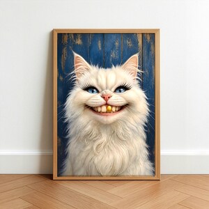 May include: A framed print featuring a whimsical white cat with blue eyes, long eyelashes, and a wide, toothy grin. The cat has a gold tooth. The background is a blue wooden panel. The frame is made of light brown wood.