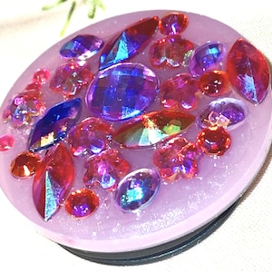 May include: A rustic wooden sign with the text "Welcome" in a handwritten style. The sign is painted white with a distressed finish, and features a decorative floral element in the corner. The background is a blurred image of a wooden surface.