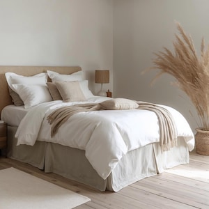 Może przedstawiać: Biały ceramiczny kubek z czarnym uchwytem i napisem "But First, Coffee" czarną, odręczną czcionką. Kubek stoi na białej powierzchni.