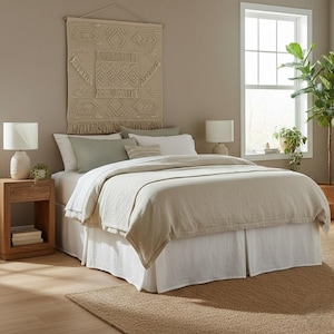 Może przedstawiać: Biały ceramiczny kubek z czarnym uchwytem i napisem "But First, Coffee" czarną, odręczną czcionką. Kubek stoi na białej powierzchni.