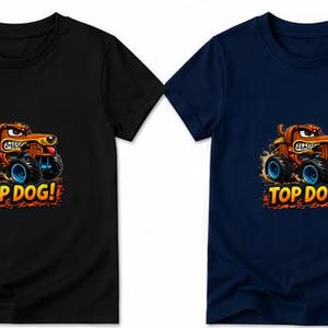 以下が含まれることがあります： 黒とネイビーブルーの2枚のTシャツ。それぞれに漫画のグラフィックが描かれています。グラフィックは、青い車輪のモンスタートラックを運転する茶色の犬を描いています。「TOP DOG！」の文字が下にあります。