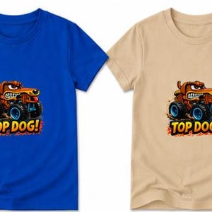以下が含まれることがあります： 青とベージュの2枚の半袖Tシャツ。それぞれに、モンスター・トラックに乗った漫画の犬が描かれています。犬は茶色で、険しい表情をしています。「TOP DOG!」の文字がグラフィックの下にあります。