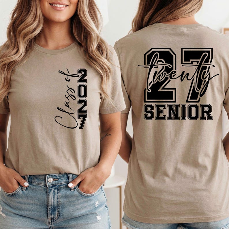 May include: Tan short-sleeved t-shirt with black text. The front of the shirt says "Class of 2027" vertically. The back of the shirt says "27 Twenty SENIOR" in a black and white design.