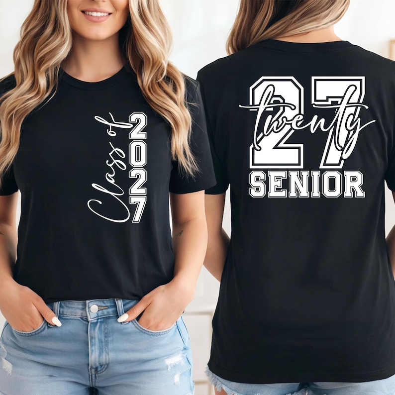 May include: Black t-shirt with white text. The front of the shirt says "Class of 2027" in a script font. The back of the shirt says "27 Twenty SENIOR" in a block font.