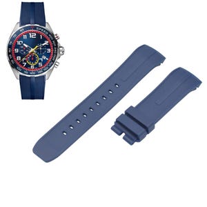 May include: A chronograph wristwatch with a silver-tone case, a dark blue dial featuring white numerals, red accents, and three sub-dials, paired with a dark blue rubber strap. Two additional dark blue rubber watch strap segments are included.