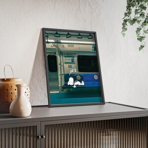 Póster con escena de un perro durmiendo en el metro, con marco de madera.