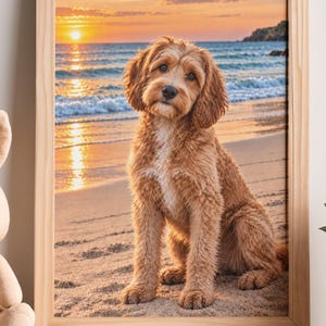 Puede incluir: Una lámina de arte enmarcada que muestra a un perro de pelaje rizado color marrón dorado sentado en una playa de arena al atardecer, con las olas del mar de fondo. Junto al marco hay un pequeño peluche de conejo color beige claro.