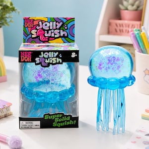 May include: A blue Jelly Squish toy in the shape of a jellyfish, with a clear, round head filled with glitter. The toy is in a clear plastic package with the words "Jelly Squish" and "Super Solid Squish!" printed on it.