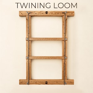 May include: A rectangular wooden twining loom featuring horizontal bars with small metal pins and two vertical metal rods secured by bolts. The text TWINING LOOM is printed above the frame, and HEIRLOOM QUALITY · BUILT TO LAST is printed below.