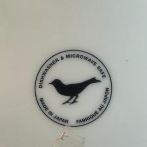 Peut inclure: Surface blanche avec un graphisme circulaire noir. Le graphisme pr&eacute;sente une silhouette d'oiseau et le texte "Dishwasher & Microwave Safe", "Made in Japan" et "Fabriqu&eacute; au Japon".