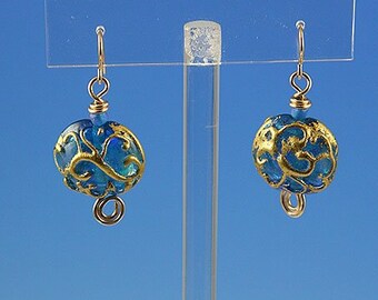 Flame worked lentil shape bead with 23.4 kt gold foil and black stringers in scroll design
