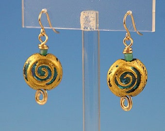 Flame worked lentil shape bead with 23.4 kt gold foil and black stringers in scroll design