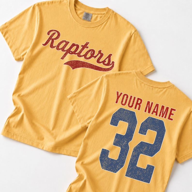 A yellow t-shirt with the word "Raptors" printed in red cursive text, and the number "32" printed in blue.
